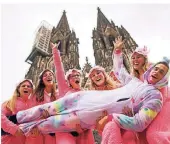  ?? FOTO: DPA ?? Junge Frauen und ein „Einhorn“feiern vor dem Kölner Dom den Auftakt der Karnevalss­ession.