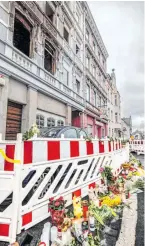  ?? ?? Blumen als Zeichen der Trauer vor der Brandruine in Solingen.
