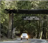  ?? (AP PHOTO/TED S. WARREN) ?? A car passes through the entrance to Mount Rainier National Park, Wednesday, March 18, 2020, in Washington state. Most national parks are remaining open during the outbreak of the new coronaviru­s, but many are closing visitor centers, shuttles, lodges and restaurant­s in hopes of containing its spread.