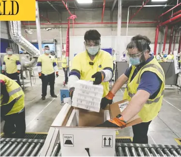  ?? MORRY GASH / POOL / GETTY IMAGES ?? Boxes containing the Pfizer-BioNTech COVID-19 vaccine are prepared to be shipped on Sunday at Pfizer's plant in Portage, Mich. They are scheduled to arrive at 145 sites on Monday, 425 on Tuesday and 66 on Wednesday.