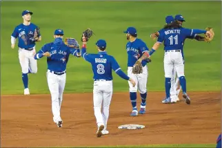  ?? Associated Press
photo ?? Toronto Blue Jays celebrate a 4-1 win over the New York Yankees in a baseball game in Buffalo, N.Y., Thursday. Toronto clinched a postseason berth with the win.