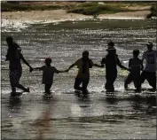  ?? ERIC GAY — THE ASSOCIATED PRESS ?? Migrants join hands as they cross the Rio Grande from Mexico into the U.S. on Thursday in Eagle Pass, Texas.