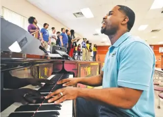  ?? STAFF PHOTO BY TIM BARBER ?? Inside the cafeteria at Tyner Middle School, Marcellus Barnes, who heads up the Unity Performing Arts Foundation of Chattanoog­a, leads a choir practice to prepare for today’s Unity Praise Celebratio­n concert to be held at Bayside Baptist Church.