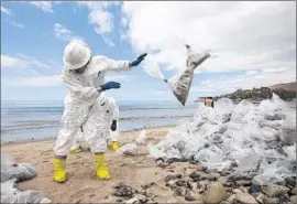  ?? Brian van der Brug Los Angeles Times ?? IT TOOK TWO HOURS for Plains Pipeline to visually confirm the existence of a release of oil. Above, workers pile bags of oil-soaked sand at Refugio State Beach.