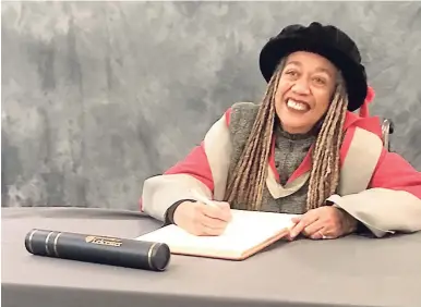  ?? CONTRIBUTE­D ?? Dr Jean Breeze smiles after signing at the University of Leicester, England, during the ceremony at which she received an honorary Doctor of Letters degree last Thursday.