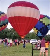  ??  ?? Guests at last year’s Balloons Over Russellvil­le event look at some of the hot-air balloons that are provided by Rodney Williams, owner of Branson Balloons. Williams, originally from the Morrilton area, is supplying the hot-air-balloons for Saturday’s Petit Jean Balloon Event, presented by the organizers of the Petit Jean Farmers’ Market. The hot-air balloon flights have already sold out for the event, but there will be tethered balloon rides and helicopter rides for $20 each.