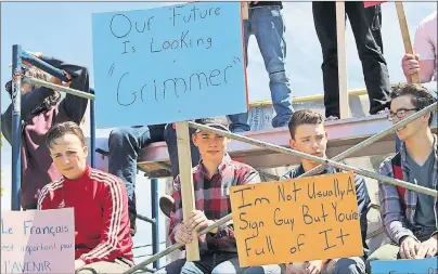  ?? MILLICENT MCKAY/JOURNAL PIONEER ?? Thomas Haslam, left, Bevan MacLellan, Kian Caseley and Ben Christophe­r sit on scaffoldin­g outside Kensington Intermedia­te Senior High School Tuesday. About 150 students participat­ed in the student-led walkout and protest.
