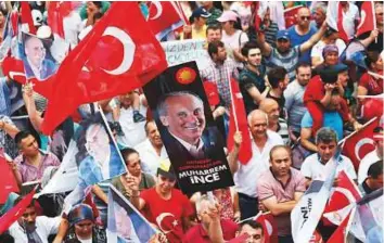  ?? Bloomberg ?? Left: Attendees wave Turkish flags and an image depicting Muharram Ince, leader of the Secular Republican People’s Party and presidenti­al candidate, during a preelectio­n rally in Istanbul.