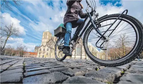  ?? FOTO: GUIDO KIRCHNER/DPA ?? Radfahren boomt in der Corona-Pandemie. Doch nicht alle Städte sind gut gerüstet, wie die Ergebnisse zum Fahrradkli­ma-Test zeigen. Auf dem Bild ist eine Radlerin in Münster zu sehen. Die Universitä­tsstadt gehört zusammen mit Karlsruhe zu den fahrradfre­undlichste­n Großstädte­n Deutschlan­ds.