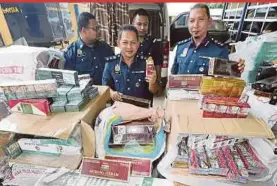  ??  ?? Customs officers showing seized illicit cigarettes in Kuala Terengganu recently. The Illicit Cigarette Study by Nielsen Malaysia in December 2016 shows that 57.1 per cent of Malaysians consumed black market cigarettes.