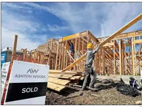  ?? AP ?? A constructi­on worker carries boards for an already-sold home under constructi­on in north Dallas in February. U.S. constructi­on spending dropped 0.6 percent in December.