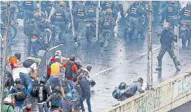  ?? REUTERS ?? Armas. Un agente apunta contra manifestan­tes en Caracas.