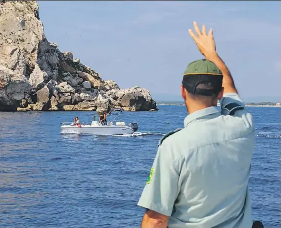  ?? AGUSTÏ ENSESA ?? Un miembro de la patrulla marítima de los agentes rurales advierte a una embarcació­n en aguas de las Medes