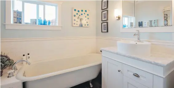  ??  ?? The bathroom is a blend of vintage (the original 1901 clawfoot tub) and modern (the subway tile and round above-counter sink).