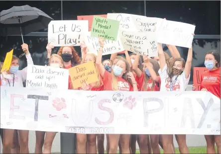  ?? OWEN MCCUE - MEDIANEWS GROUP ?? Owen J. Roberts athletes hold up their signs during a rally outside the Chester County Department of Health on Monday in West Chester.