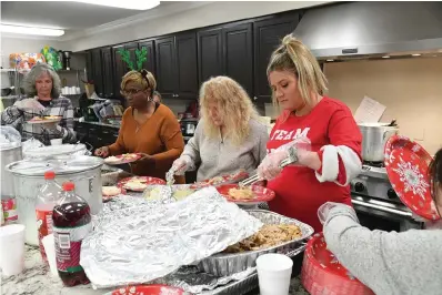  ?? The Sentinel-Record/Tanner Newton ?? Volunteers make Christmas meals for the homeless at Lakeview Assembly Church for their annual Christmas party for the homeless.