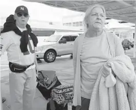  ?? MARTA LAVANDIER/AP ?? Kim Newton and her husband, Matt Daly, of Surf City, N.C., wait for a taxi after Norwegian Cruise Line canceled their vacation on the Getaway ship with short notice on Wednesday in Miami. Daly and Newton are on their honeymoon.