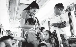  ??  ?? Actress Estefania Rebellón, who formed Yes We Can World Foundation, greets the students in the converted bus. Originally from Colombia, Rebellón and her family sought asylum in the United States 18 years ago.