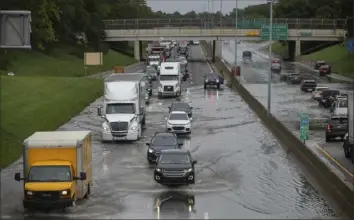  ?? David Rodriguez Munoz/Detroit Free Press via AP ?? Dozens of vehicles drive through a flooded section of I-94 and Livernois on Friday in Detroit.