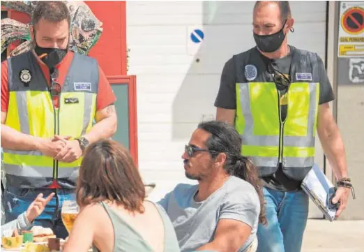  ?? EFE ?? La Policía controla el cumplimien­to de las medidas contra la pandemia en una terraza de Palma de Mallorca