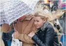  ??  ?? Wet, windy walk: Shoppers struggle along Oxford Street in central London.