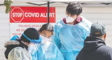  ?? THE CANADIAN PRESS FILES ?? Intake workers assist visitors at an immigrant and refugee vaccine clinic set up by Global Medic in Toronto on April 27.