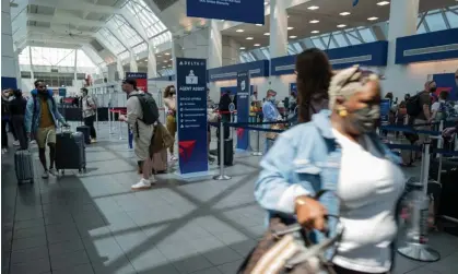  ?? ?? A traveler rushes through the terminal at JFK airport in New York. Flight cancellati­ons hit Delta hardest, with 6% of its total flights called off on Sunday and 200 early Monday. Photograph: Spencer Platt/Getty Images