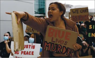  ?? NHAT V. MEYER — STAFF PHOTOGRAPH­ER ?? A protester yells at San Jose police officers during a protest of the killing of George Floyd outside of San Jose City Hall on Sunday.