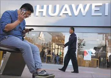  ?? Ng Han Guan Associated Press ?? UNDER THE U.S. ban, users of existing Huawei phones would retain access to Google Play. But the Chinese firm’s future phones will lose access to Google services and Android updates. Above, a store in Beijing.