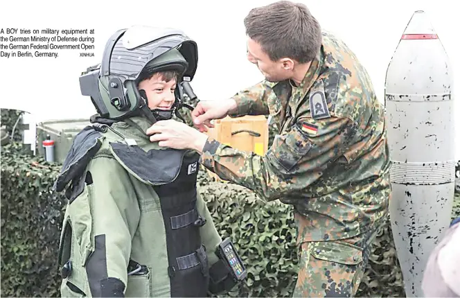  ?? XINHUA ?? A BOY tries on military equipment at the German Ministry of Defense during the German Federal Government Open Day in Berlin, Germany.
