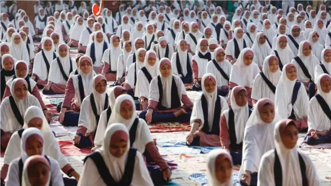  ??  ?? Indian Muslim students practice yoga ahead of Internatio­nal Yoga Day celebratio­ns, at a school in Ahmadabad, India, Saturday. Internatio­nal Yoga Day will be celebrated on June 21.—AP