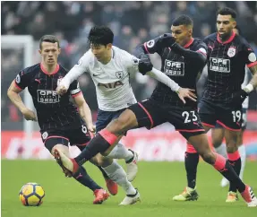 ?? EPA ?? Tottenham Hotspur’s Heung-min Son fights his way past Huddersfie­ld defenders at Wembley Stadium yesterday. Son scored both goals for Spurs in a 2-0 win
