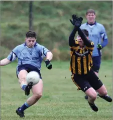  ??  ?? Shillelagh’s Brendan Behan fires over a point despite the best efforts of Enniskerry’s Mark Mullen.