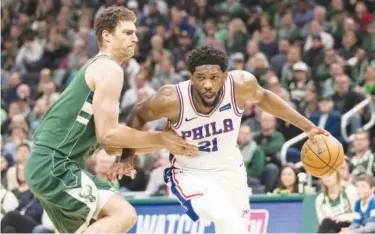  ?? Reuters ?? ↑ Philadelph­ia 76ers’ Joel Embiid (21) drives for the basket against Milwaukee Bucks’ Brook Lopez (11) during their NBA game on Sunday.