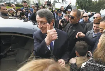  ?? Petros Karadjias / Associated Press ?? Cyprus President Nicos Anastasiad­es greets supporters after casting his ballot in the southern city of Limassol. Anastasiad­es defeated challenger Stavros Malas by a wide margin.