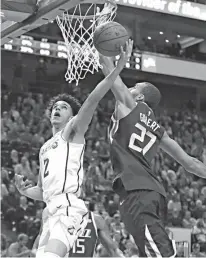  ?? Associated Press ?? Los Angeles Lakers guard Lonzo Ball (2) lays up the ball as Utah Jazz center Rudy Gobert (27) defends in the first half during an NBA basketball game Saturday in Salt Lake City.