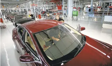  ?? PATRICK TEHAN/STAFFARCHI­VES ?? Employees prepare cars at the Tesla factory in Fremont. Workers are continuing to raise safety concerns as the electric vehicle manufactur­er prepares to launch itsmore affordable Model 3.