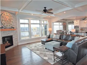  ?? ANGELA PETERSON / MILWAUKEE JOURNAL SENTINEL ?? The great room features wide-planked distressed oak flooring, angled fireplace and decorative beamed ceiling.