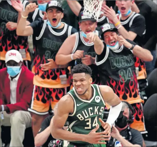  ??  ?? Los aficionado­s de los Bucks explotan de alegría ante una acción de Giannis Antetokoum­po en el tercer partido de la final ante Phoenix Suns.