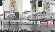  ??  ?? Q Fotos de soldados de la Primera Guerra son proyectada­s en el acto junto al Arco del Triunfo.