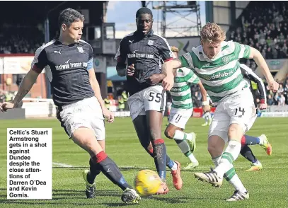  ??  ?? Celtic’s Stuart Armstrong gets in a shot against Dundee despite the close attentions of Darren O’Dea and Kevin Gomis.