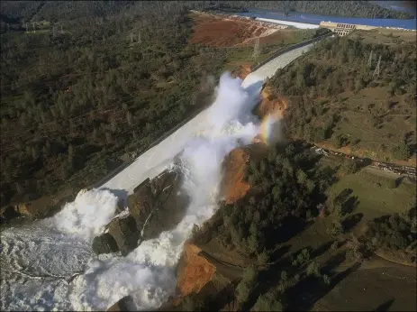  ?? OF WAter reSourCeS VIA AP ?? this Feb. 11, 2017 file aerial photo released by the California Department of Water Resources shows the damaged spillway with eroded hillside in Oroville. One year after the closest thing to disaster at a major U.S. dam in a generation, federal dam...