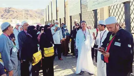  ??  ?? Pembimbing ibadat memberi taklimat kepada jemaah haji Malaysia yang melakukan ziarah luar di Bukit Uhud.