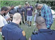  ?? JIM WEBER/THE COMMERCIAL APPEAL ?? DeVante Hill with One Memphis leads a prayer with Memphis police officers at Martin Luther King Jr. Park on July 17 during a short vigil for peace.