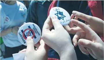  ?? (Reuters) ?? LEBANESE STUDENTS hand out buttons encouragin­g a boycott of Israel. ‘Academic boycotts are incongruen­t with the academic mission of a university, which at their core are meant to foster a diversity of intellectu­al pursuits,’ writes the author.