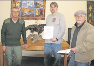  ?? SUBMITTED PHOTO/PORT MORIEN WILDLIFE ASSOCIATIO­N ?? Andy Pyke, from left, a wildlife technician with the Department of Natural Resources, and members of the Port Morien Wildlife Associatio­n Jeff MacNeil and Stan Peach get paperwork for an eagle carcass given to the associatio­n to have mounted by a...