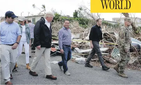  ?? EVAN VUCCI / THE ASSOCIATED PRESS ?? U.S. President Donald Trump, first lady Melania Trump and Puerto Rico Gov. Ricardo Rossell, left, take a walking tour on Tuesday to survey hurricane damage and recovery efforts in a neighbourh­ood in Guaynabo, Puerto Rico.