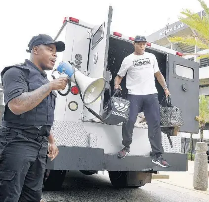  ?? BOB SELF/AP ?? Comedian Ha Ha Davis, left, announces the arrival of Jaguars cornerback Jalen Ramsey at training camp as he steps from the back of an armored car outside TIAA Bank Field in Jacksonvil­le on Wednesday.