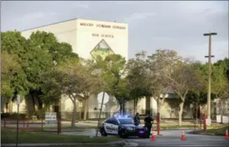  ?? MIKE STOCKER — SOUTH FLORIDA SUN-SENTINEL VIA AP, FILE ?? Police watch the entrance of a parking lot at Marjory Stoneman Douglas High School in Parkland, Fla.