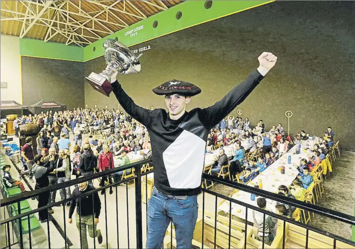  ?? FOTO: LUIS MARI UNCITI ?? Jokin Altuna levanta el trofeo que le acredita como campeón del Manomanist­a en su edición del 2018 delante de toda la gente que le acompañó en la cena que se celebró en el frontón del pueblo